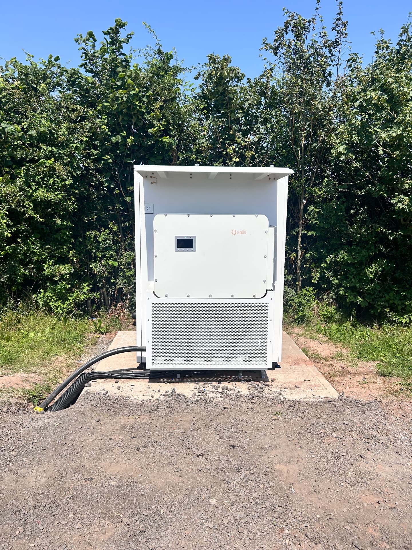 Commercial hybrid inverter installed in a weather-protected enclosure with cable containment