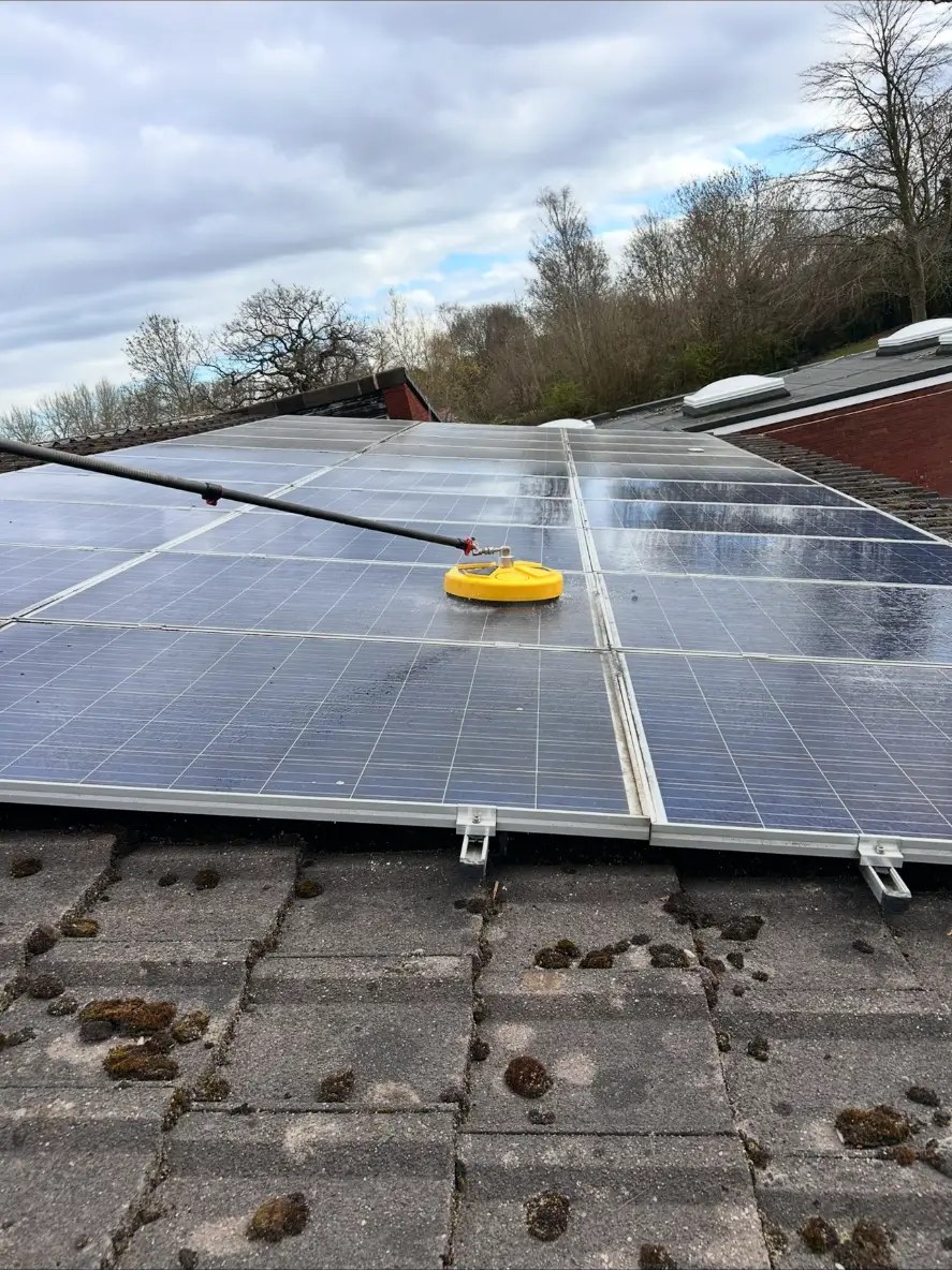 Solar panels being cleaned on a school rooftop